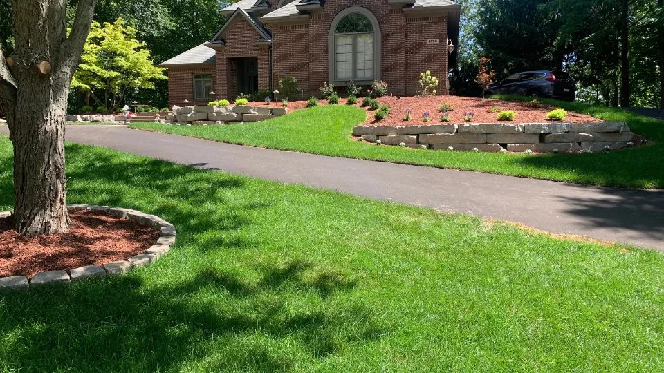 Large Flat Stone Retaining Wall With Mulched Flower Beds, Brick Paver Walkway and Stairs